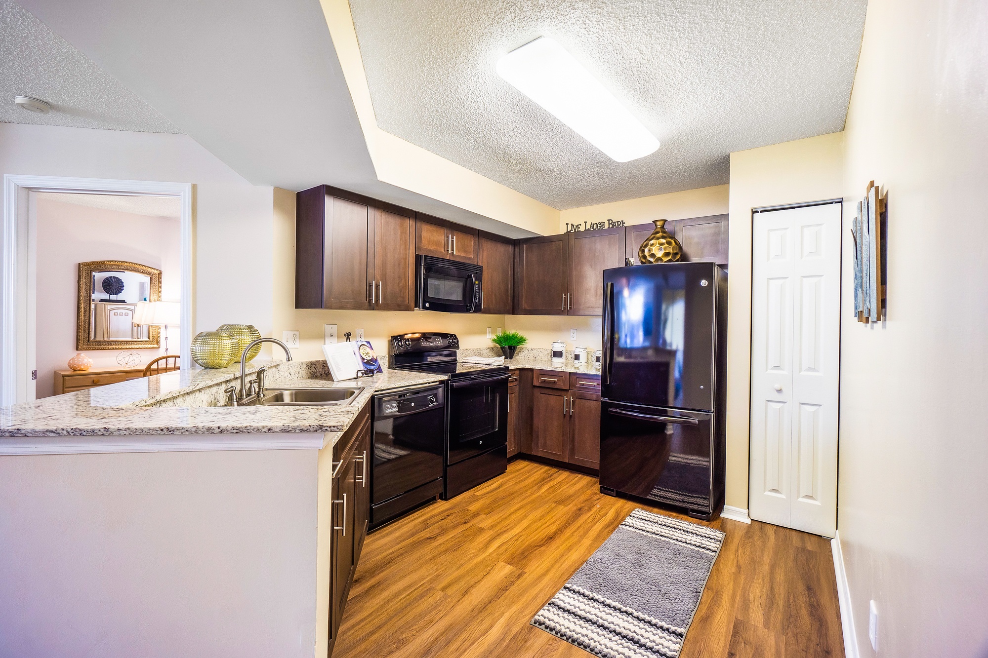 A kitchen with a black fridge and a black oven.